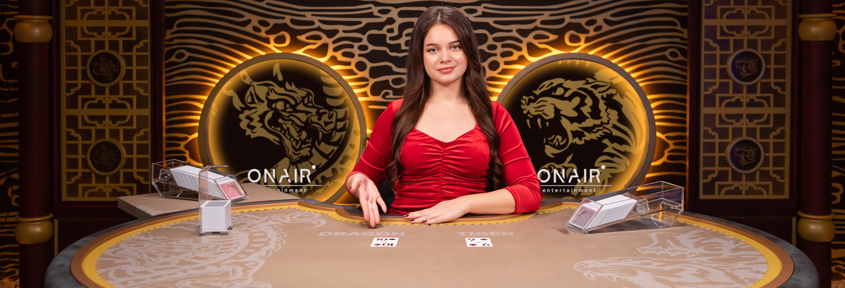 Female game presenter behind a game table presenting two cards in a game of Blazing Dragon Tiger.