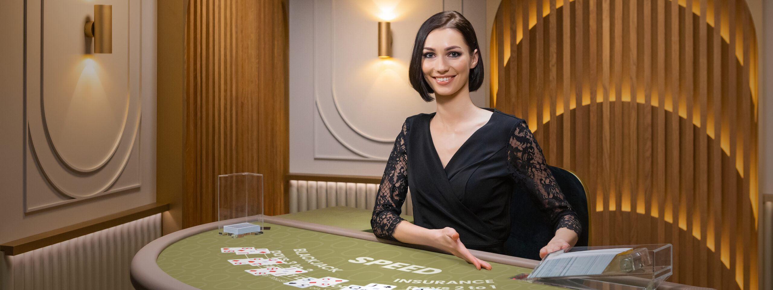 Female game presenter behind a Blackjack table in Speed Blackjack.